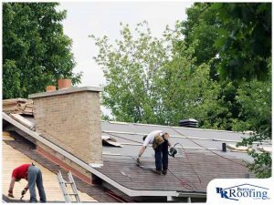 technicians installing asphalt shingle roofing on home that was recently damaged in a storm